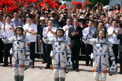 Mission commander Jing Haipeng (R) with fellow astronauts Liu Wang (C) and Liu Yang, China's first female astronaut, wave to the crowd prior to boarding the Shenzhou-9 spacecraft on June 16. The crew's main task during their 13-day mission is to carry out China's first manual space docking