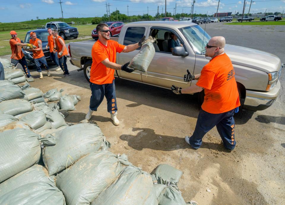 St. Bernard Parish Sheriff's Office inmate workers move free sandbags for residents in Chalmette, La., Thursday, July 11, 2019 ahead of ahead of Tropical Storm Barry from the Gulf of Mexico. (AP Photo/Matthew Hinton)