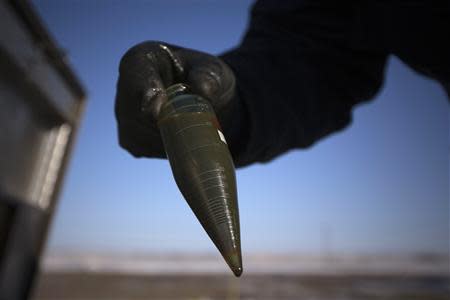 A man demonstrates how an oil sample is taken at a drilling rig site outside of Williston, North Dakota in this March 12, 2013 file photo. REUTERS/Shannon Stapleton/Files