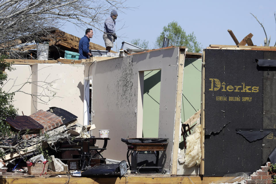 People work at a damaged home Tuesday, April 14, 2020, in Chattanooga, Tenn. Tornadoes went through the area Sunday, April 12. (AP Photo/Mark Humphrey)