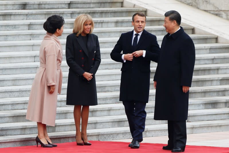 French President Emmanuel Macron and his wife Brigitte Macron attend a welcome ceremony with Chinese President Xi Jinping and his wife Peng Liyuan outside the Great Hall of the People in Beijing