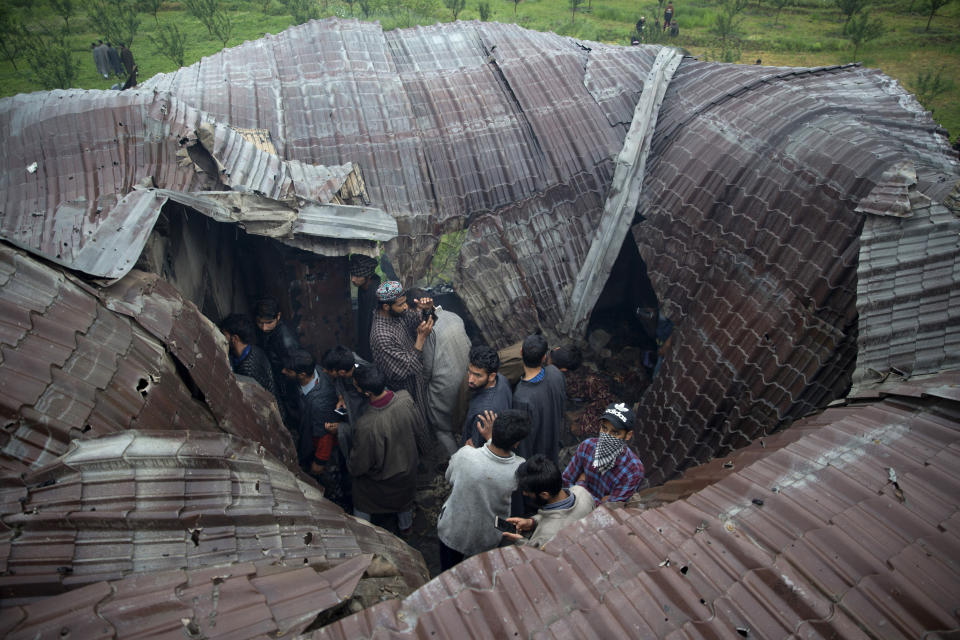 Kashmiri villagers inspect a damaged house after a gunbattle in Tral, south of Srinagar, Indian-controlled Kashmir, Friday, May 24, 2019. Government forces in Indian-controlled Kashmir killed a top militant commander linked to al-Qaida in the disputed region, officials said on Friday. (AP Photo/ Dar Yasin)