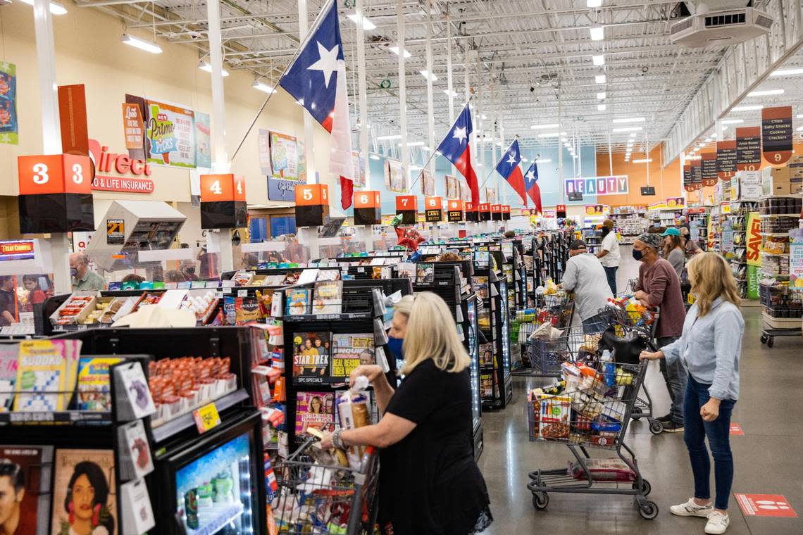 Texas flags over the cash registers as customers wait to check out at the H-E-B in Hudson Oaks in March 2021.