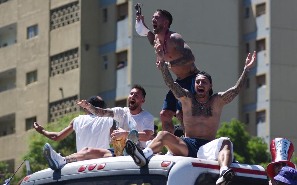 Lionel Messi, Rodrigo De Paul, Leandro Paredes y sus compañeros de Argentina celebran en el autobús con el trofeo de la Copa del Mundo durante el desfile de la victoria - Reuters