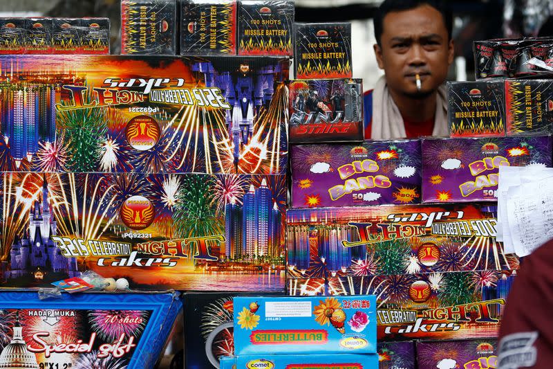 A vendor selling fireworks waits for customers at a market in Jakarta