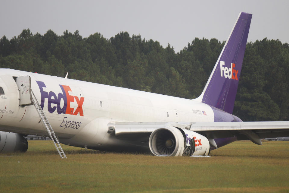 A FedEx 757 sits on a landing strip Thursday, Oct. 5, 2023 at the Chattanooga Metropolitan Airport after crash landing late Wednesday evening. Officials say the FedEx plane skidded off the runway during a crash landing when its landing gear did not descend, but no one was injured. (Olivia Ross /Chattanooga Times Free Press via AP)