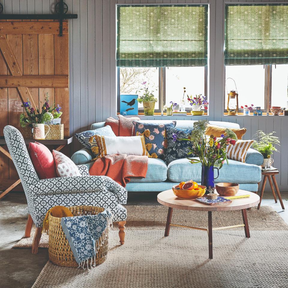 A rustic living room with a blue sofa and a jute rug