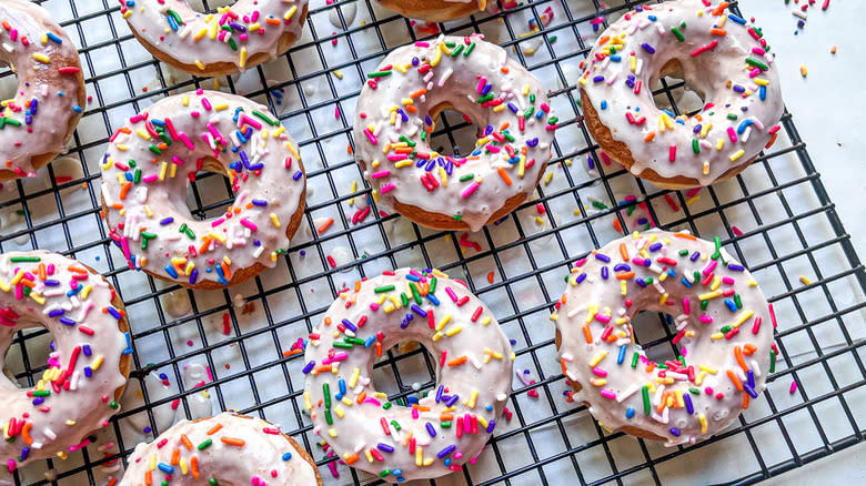 Sprinkled donuts on wire rack