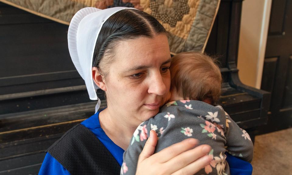 Lydia Stoltzfus holds her youngest child while staying at a home in northeastern Lancaster County.