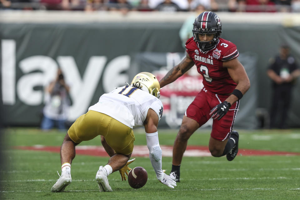 Notre Dame safety Ramon Henderson (11) recovers a South Carolina fumble in front of South Carolina wide receiver Antwane Wells Jr. (3), right, during the first quarter of the Gator Bowl NCAA college football game on Friday, Dec. 30, 2022, in Jacksonville, Fla. (AP Photo/Gary McCullough)