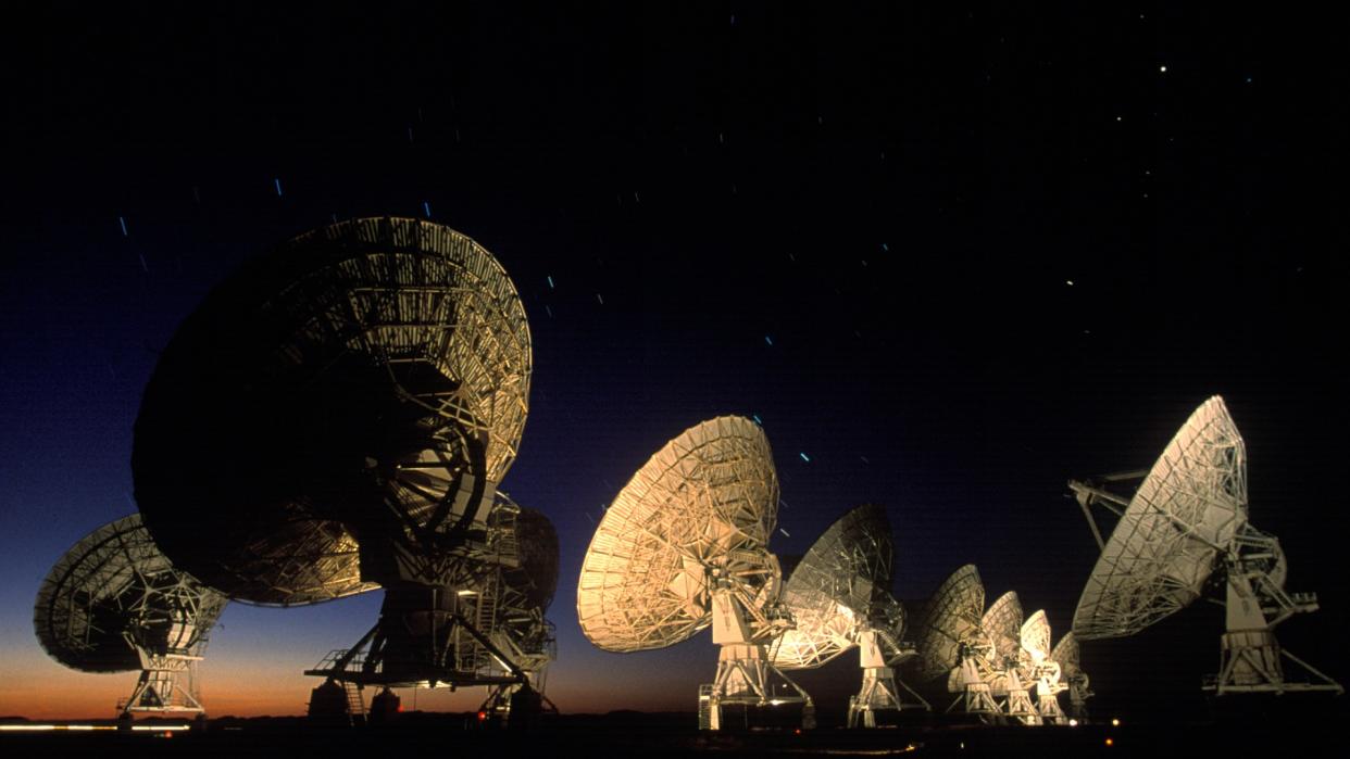  large radio telescopes at night in the desert 