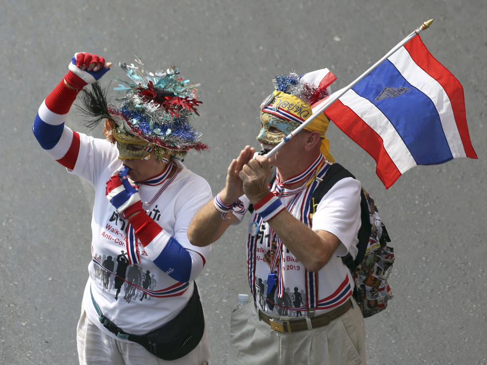 A foreign couple dressed up as they join anti-government protesters during a rally in Bangkok, Thailand, Saturday, Jan. 25, 2014. Thailand's ruling party has questioned the reasoning behind a court decision allowing next month's general election to be postponed, but held open the possibility that it might agree to put off the polls if its political rivals agree to recognize the legitimacy of a new vote. (AP Photo/Apichart Weerawong)