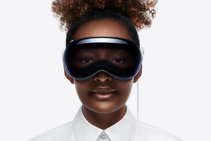 Una persona che indossa un visore Apple Vision Pro.  I loro occhi possono essere visti attraverso la parte anteriore del dispositivo.