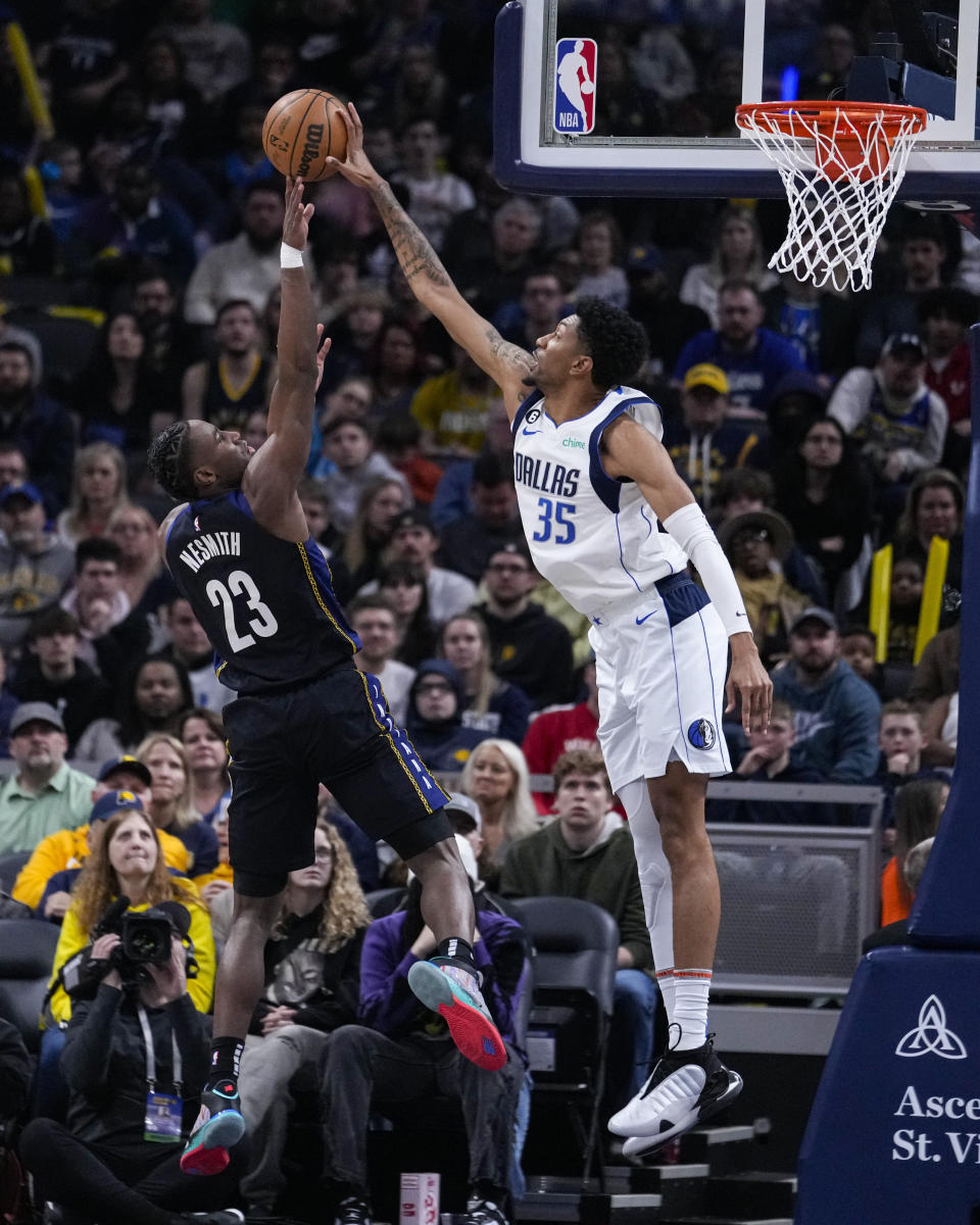 Dallas Mavericks forward Christian Wood (35) blocks the shot of Indiana Pacers forward Aaron Nesmith (23) during the first half of an NBA basketball game in Indianapolis, Monday, March 27, 2023. (AP Photo/Michael Conroy)