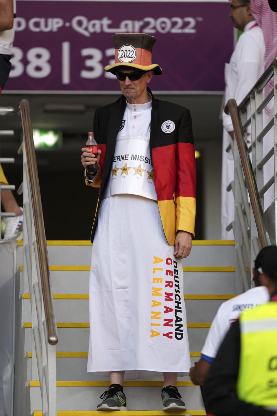 FILE - A German supporter holds a Coca Cola instead of a beer on the tribune prior to the World Cup group E soccer match between Germany and Japan, at the Khalifa International Stadium in Doha, Qatar, Wednesday, Nov. 23, 2022. (AP Photo/Matthias Schrader, File)