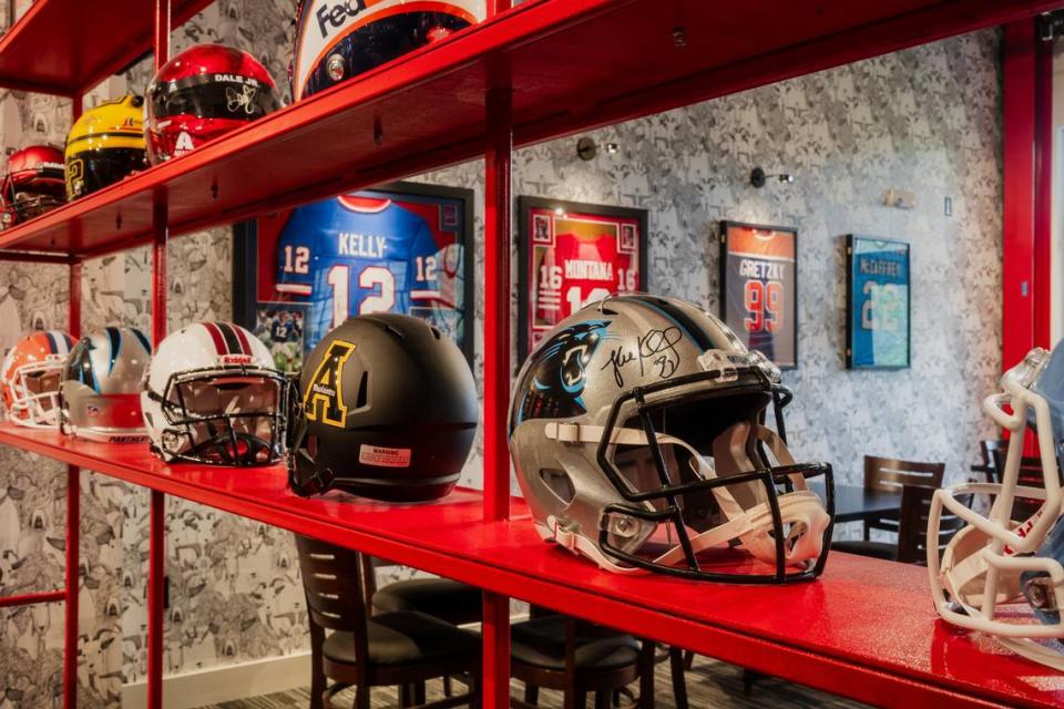 Among the helmets on display at G.O.A.T. Pizza, you can find ones worn by Luke Kuechly, Denny Hamlin and Joey Logano.