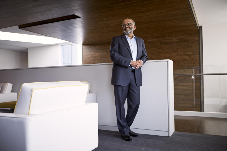 Adobe CEO Shantanu Narayen standing in the company's contemporary office space.