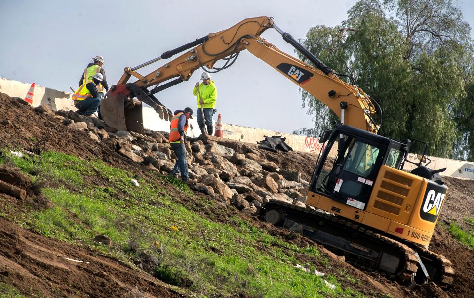 A Caltrans crew works on slope repair to the connecting ramp from southbound Interstate 5 to the westbound Crosstown Freeway in Stockton on Friday, Jan. 6, 2023. The raised freeway was damaged due to erosion from recent storms. The ramp as well as a lane of W. Washington Street at the bottom of the slope were closed for about a day for the repairs.