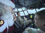 Santa and Mrs. Claus chat with the flight crew of an Alaska National Guard cargo plane while en route to Nuiqsut, Alaska, on Tuesday, Nov. 29, 2022. Operation Santa Claus, the guard's outreach program, attempts to bring Santa and Mrs. Claus and gifts to children in two or three Alaska Native villages each year. (AP Photo/Mark Thiessen)