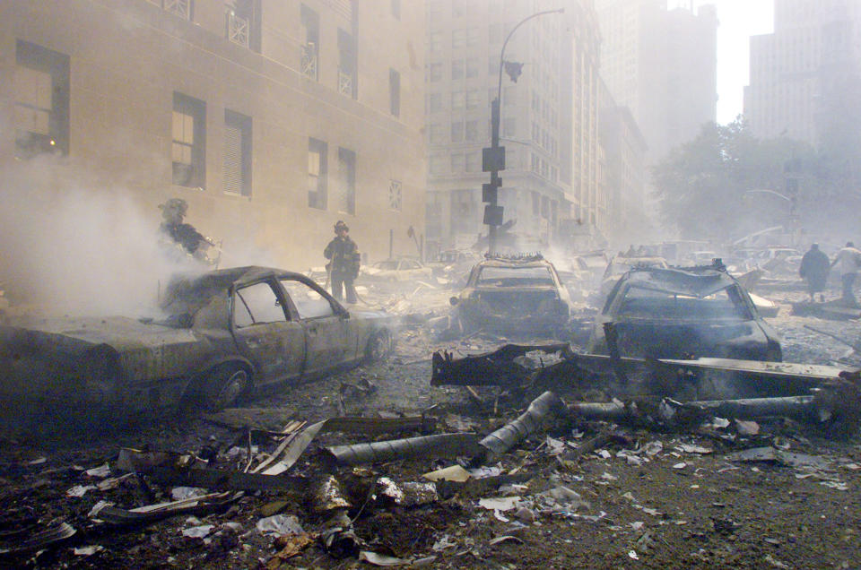 Varios coches arden en la calle mientras las Torres Gemelas siguen en llamas el 11-S.<br><br>Foto: REUTERS/Peter Morgan
