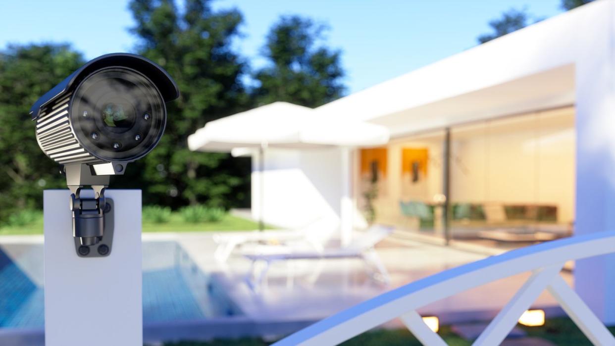 exterior of a villa with security camera at the entrance of the garden