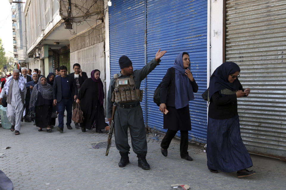 Staff of the Telecommunication Ministry are escorted after an attack outside the ministry building in Kabul, Afghanistan, Saturday, April 20, 2019. Afghan officials say an explosion has rocked the telecommunications ministry in the capital city of Kabul. Nasart Rahimi, a spokesman for the interior ministry, said Saturday the blast occurred during a shootout with security forces. (AP Photo/Rahmat Gul)