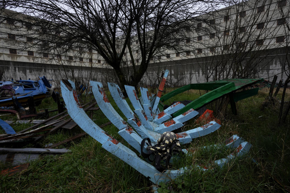 Wrecked migrants' boats lie inside the facilities of Milan's Opera maximum security prison near Milan, northern Italy, Friday, Feb. 9, 2024. Inmates at Opera took the wood of wrecked boats sailed by migrants across the Sicily Channel to craft the musical instruments that the 'Sea Orchestra' used during their debut at La Scala Opera House in Milan on Monday, Feb. 12, 2024. The violins, violas and cellos played by the Orchestra of the Sea in its debut performance Monday at Milan's famed Teatro all Scala carry with them tales of hardship. (AP Photo/Antonio Calanni)