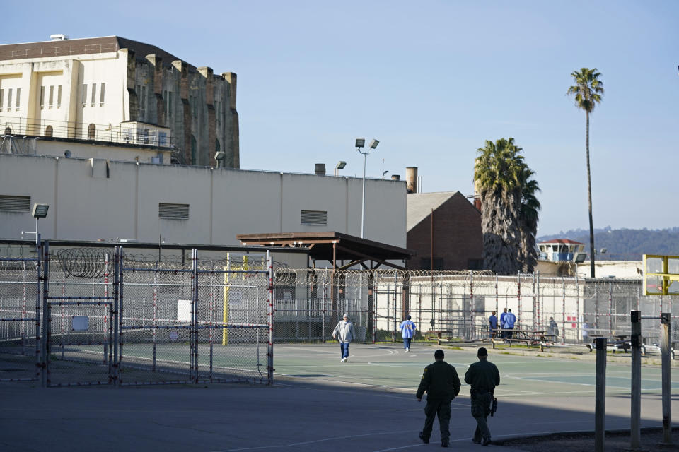 A pair of correctional officers walk through the exercise yard at San Quentin State Prison in San Quentin, Calif., Friday, March 17, 2023. Gov. Gavin Newsom plans to transform San Quentin State Prison, a facility in the San Francisco Bay Area known for maintaining the highest number of prisoners on death row in the country. Newsom said his goal is to turn the prison into a place where inmates can be rehabilitated and receive job training before returning to society. (AP Photo/Eric Risberg)