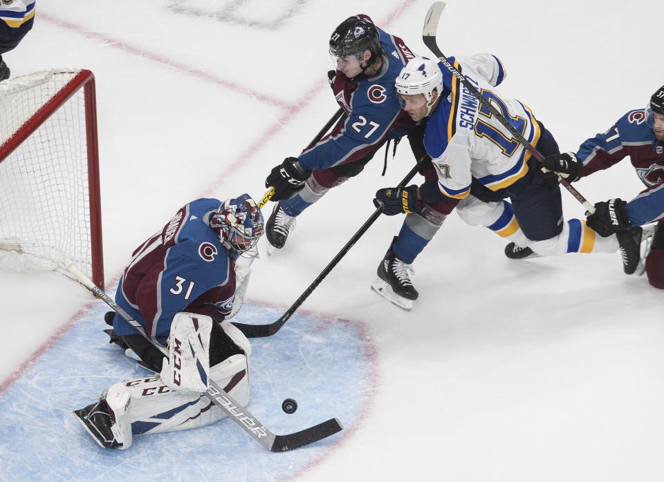 Colorado Avalanche goalie Philipp Grubauer (31) makes a save on St. Louis Blues' Jaden Schwartz (17) as Ryan Graves (27) defends during the third period of an NHL hockey playoff game Sunday, Aug. 2, 2020, in Edmonton, Alberta. (Jason Franson/The Canadian Press via AP)