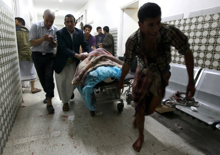 Yemenis transport a severely injured man on a gurney as he arrives at a hospital in Sanaa after being injured when two suicide bombers hit a Shiite mosque in quick succession, September 2, 2015