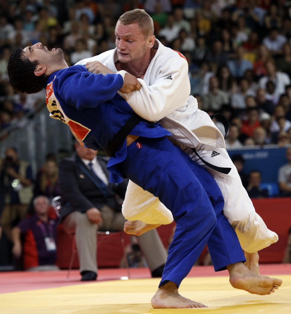 Tagir Khaibulaev of Russia, (in blue), competes against Dimitri Peters of Germany during the men's under 100-kg judo competition at the 2012 Summer Olympics, Thursday, Aug. 2, 2012, in London. (AP Photo/Paul Sancya)