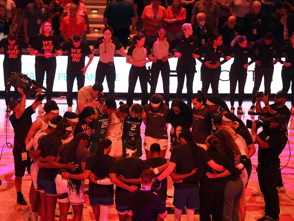 Players with the Connecticut Sun and Phoenix Mercury link arms for 42 seconds in honor of Phoenix Mercury center Brittney Griner before a game in August. (Sarah Gordon/The Day via AP)