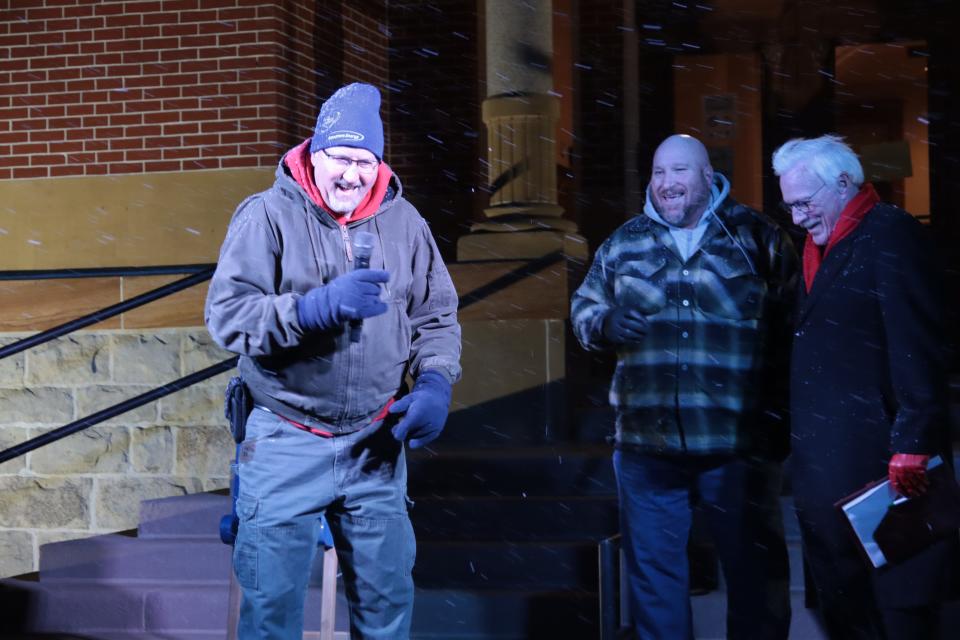 Dave Southward of Consumers Energy, left, talks Monday during the Community Christmas Tree lighting ceremony at the old Lenawee County Courthouse lawn. Listening are, H.L. Green of H.L. Green Machine Moving in Adrian, center, and Community Christmas Tree coordinator Jim Berryman. Consumers set up the tree in the lawn and strung the lights.