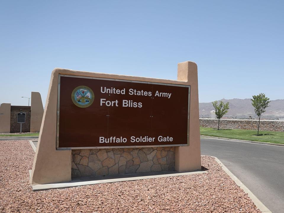 A "Fort Bliss" sign planted along the left side of a road in Texas.