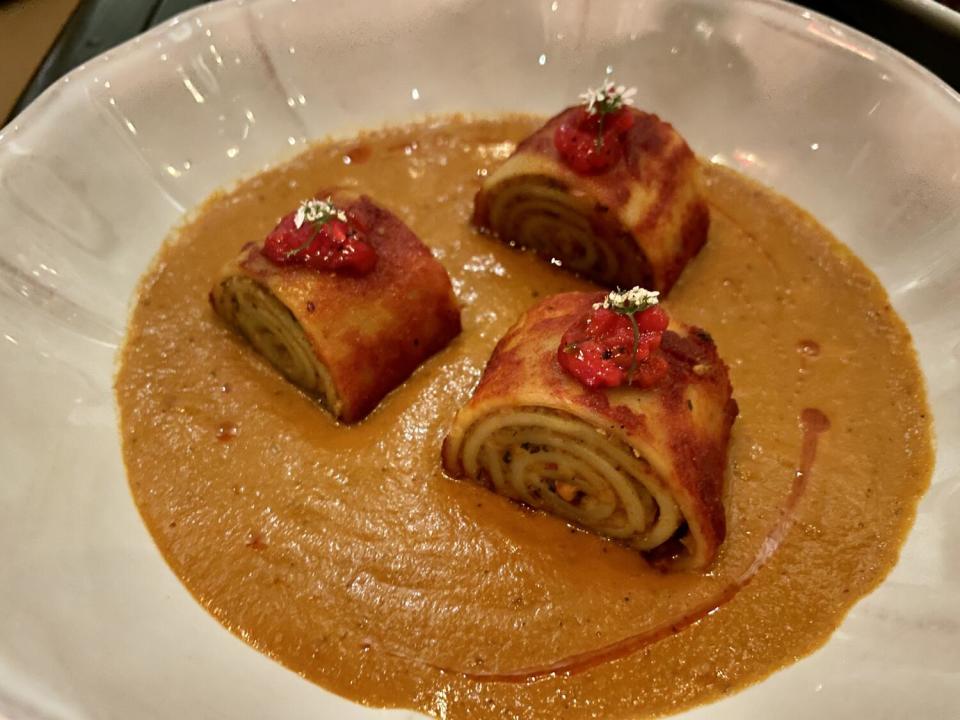 Three paneer pinwheels in a pool of sauce from Baar Barr in downtown L.A.