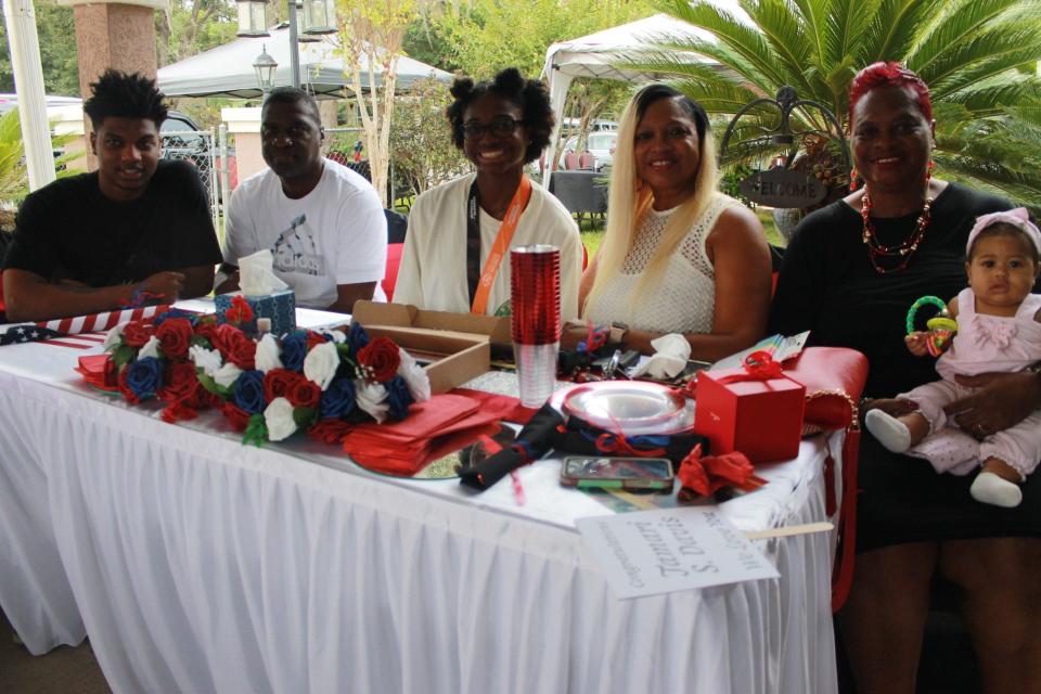 Tamari Davis, center, who ran the first leg for the U.S. 4X100 Meter Relay Team that won the Gold Medal at the World Athletics Championships in Budapest, Hungary last month, was the guest of honor at an event celebrating her accomplishment. She is flanked from the left by her brother Desmond Davis, father Derrill Davis, mother Tamara Davis, and grandmother Shirline Able holding her great-great niece Reneé Roberts.
(Credit: Photo by Voleer Thomas/For The Guardian)