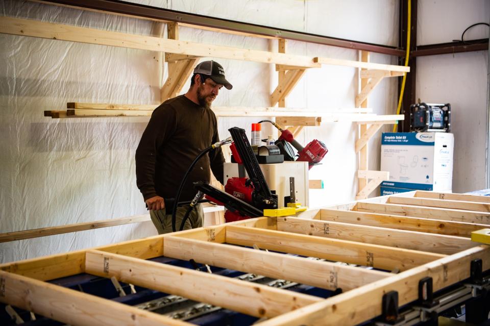 In this file photo, Gabriel Dickinson assists in the construction of a prefab home at Compact Cottages in Fletcher. The company has seen an increase in building demand, but it's having trouble filling a job for a superintendent-level position with pay starting in the $60,000-plus range.