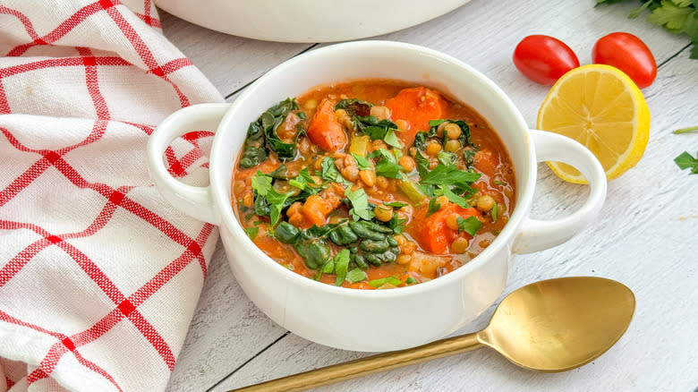 kale lentil vegetable soup in bowl with spoon