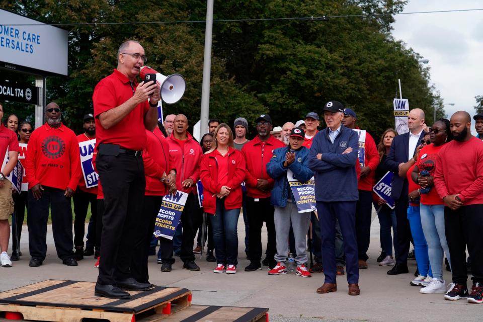 President Joe Biden listens to UAW president Shawn Fain speak with workers picketing at General Motors Willow Run Redistribution in Van Buren Township on Tuesday, Sept. 26, 2023, during a stop in Michigan.