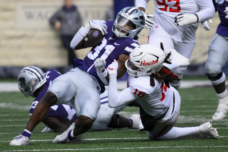 Kansas State running back DJ Giddens (31) is tackled by Houston defensive back Brian George (16) during the second half of an NCAA college football game in Manhattan, Kan., Saturday, Oct. 28, 2023. (AP Photo/Reed Hoffmann)