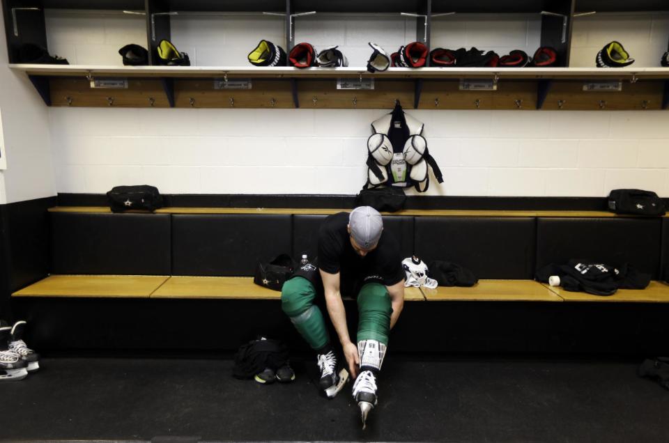 Dallas Stars' Jamie Benn removes his skates following an NHL hockey practice Tuesday, March 11, 2014, in St. Louis. Dallas Stars' Rich Peverley is undergoing testing to determine what triggered his collapse during a game Monday night in Dallas. The Stars are scheduled to play the St. Louis Blues tonight in St. Louis. (AP Photo/Jeff Roberson)