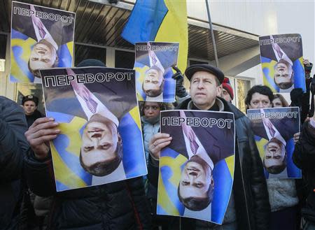 Protesters hold upturned portraits of Ukrainian President Viktor Yanukovich during a protest rally in front of the Ukrainian Ministry of Internal Affairs in Kiev, December 26, 2013. The text on the portraits reads "Upturn" (which in Ukrainian is synonymous with coup). REUTERS/Gleb Garanich
