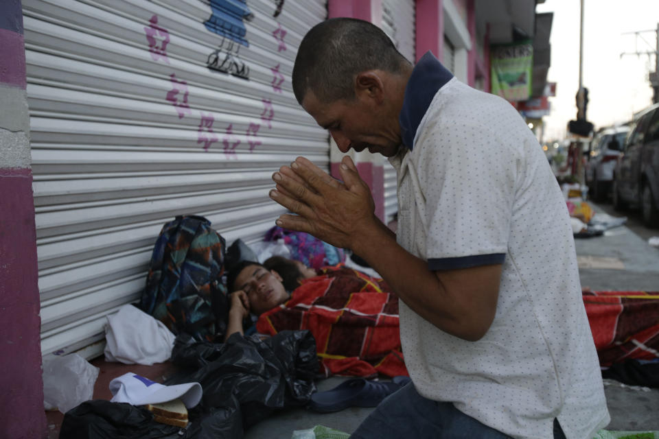 Marvin Sanabria, a Central American migrant traveling with a caravan to the U.S., kneels in prayer after waking up, in Huixtla, Mexico, Tuesday, Oct. 23, 2018. The caravan, estimated to include more than 7,000 people, had advanced but still faced more than 1,000 miles, and likely much further, to the end of the journey. (AP Photo/Moises Castillo)