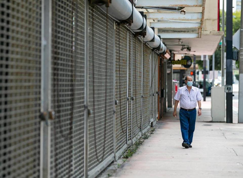 Un hombre pasa por delante de los escaparates cerrados del emprendedor Moishe Mana en Southeast First Street, en el downtown de Miami.