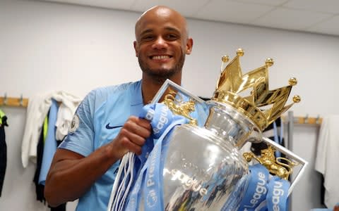 Vincent Kompany of Manchester City celebrates with the Premier League Trophy after winning the title following the Premier League match between Brighton & Hove Albion and Manchester City - Credit: GETTY IMAGES