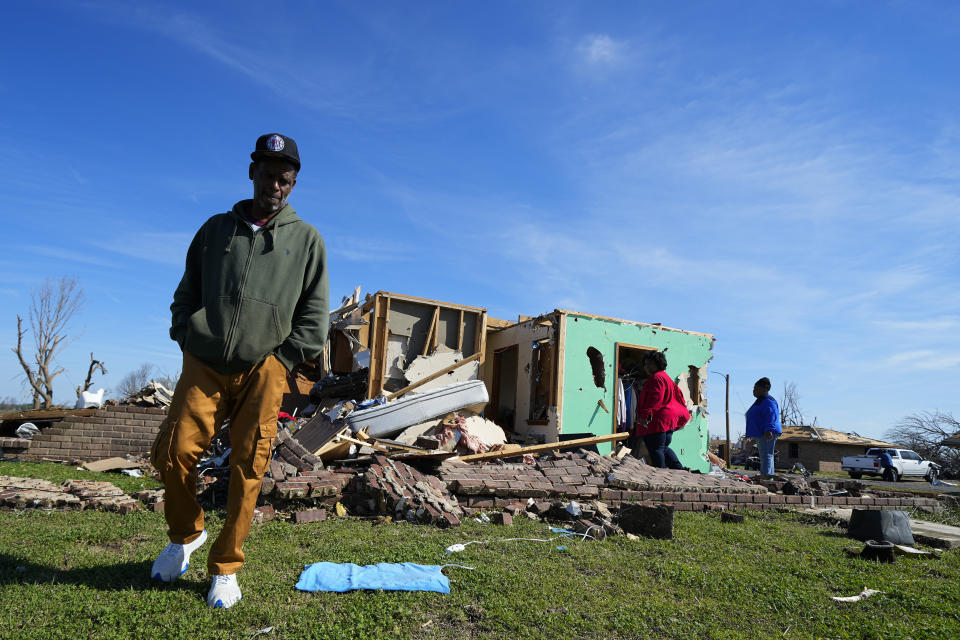 FILE - Jermaine Wells, neighbor of Lonnie and Melissa Pierce, who were killed when the truck landed on their house during a tornado, walks near Wells' home, March 27, 2023, in Rolling Fork, Miss. An unusual weather pattern has set in, triggering the devastating tornado that hit Rolling Fork, and meteorologists fear this Friday, March 31, will be one of the worst days, with much more to come. (AP Photo/Julio Cortez, File)