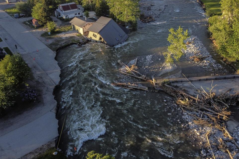 A house sits in Rock Creek after floods washed away a road and a bridge in Red Lodge, Mont., on June 15, 2022. (AP Photo/David Goldman)