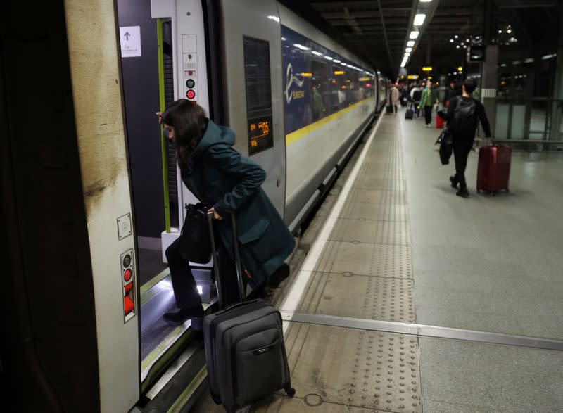 A woman enters a Eurostar train travelling from London to Paris, in London