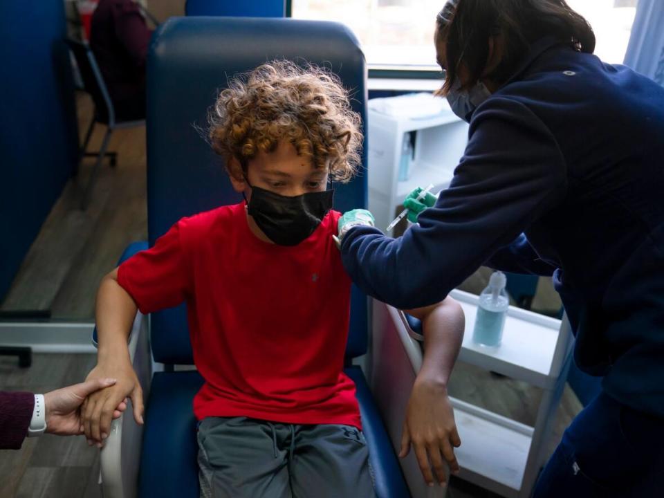 Max Cuevas, 12, holds his mother's hand as he receives the Pfizer COVID-19 vaccine from a nurse practitioner in Tustin, Calif., in May. On Friday, the U.S. Food and Drug Administration posted its analysis of Pfizer's data concerning its COVID vaccine for children ages 5 to 11. (Jae C. Hong/Associated Press - image credit)