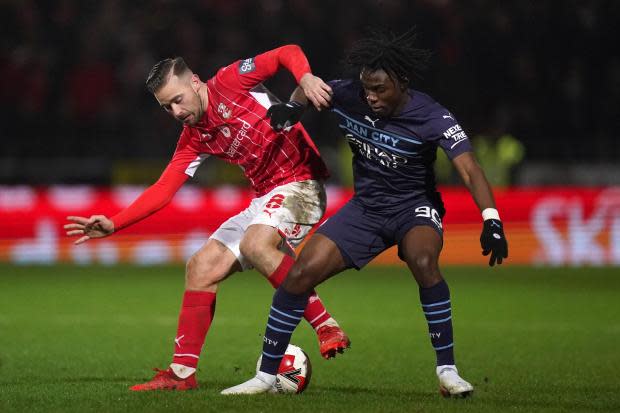 Swindon Town's Jordan Lyden (left) and Manchester City's Romeo Lavia battle for the ball during the Emirates FA Cup third round match at the Energy Check County Ground, Swindon. Picture date: Friday January 7, 2022..